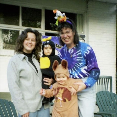 Two women and two small kids in Halloween costumes.