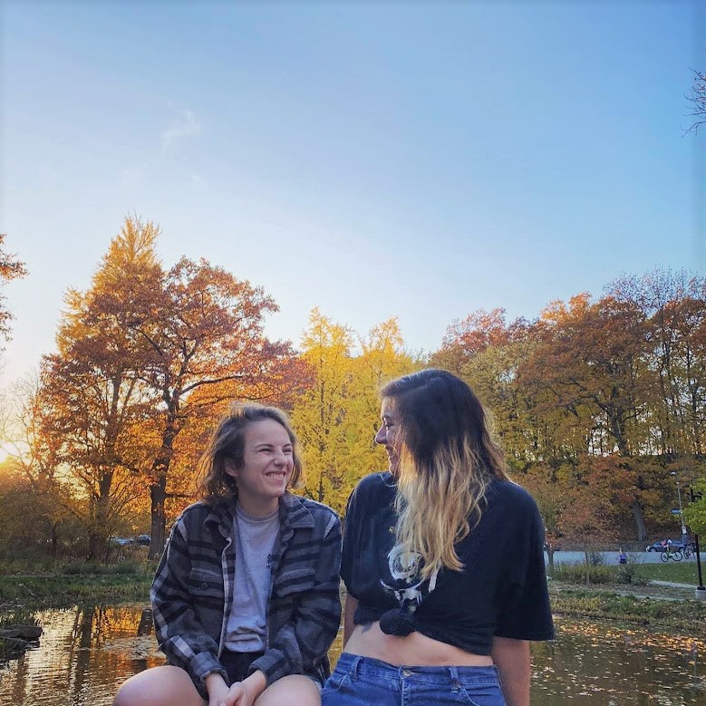 Two young women smiling at each other.